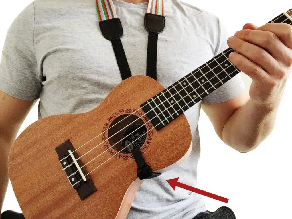 ukulele with ukulele strap hooked into the sound hole